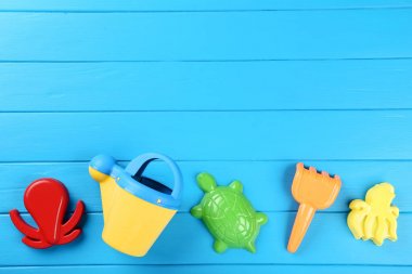 Mavi ahşap masa üzerinde plastik plaj oyuncakları
