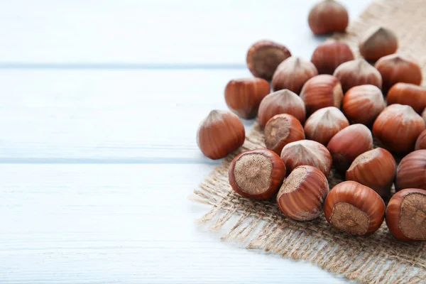 Mogna hasselnötter med säckväv på träbord — Stockfoto