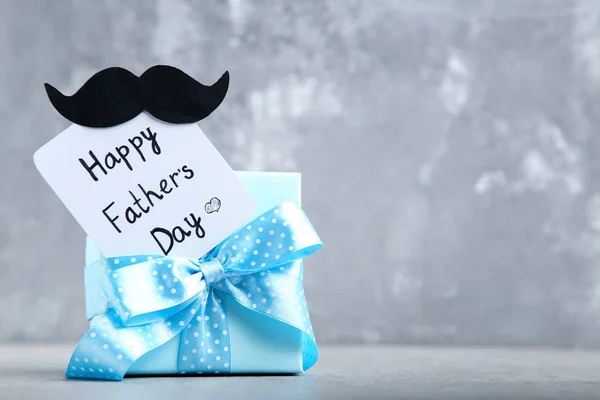 Text Happy Fathers Day with blue gift box on grey background — Stock Photo, Image