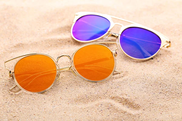 Барвисті сонцезахисні окуляри на пляжному піску — стокове фото