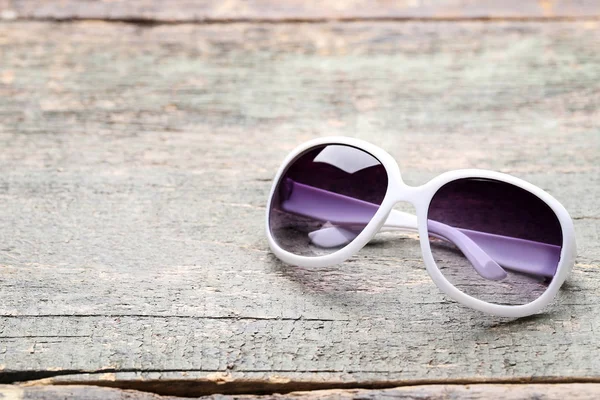 Modne okulary przeciwsłoneczne na szarym drewnianym stole — Zdjęcie stockowe