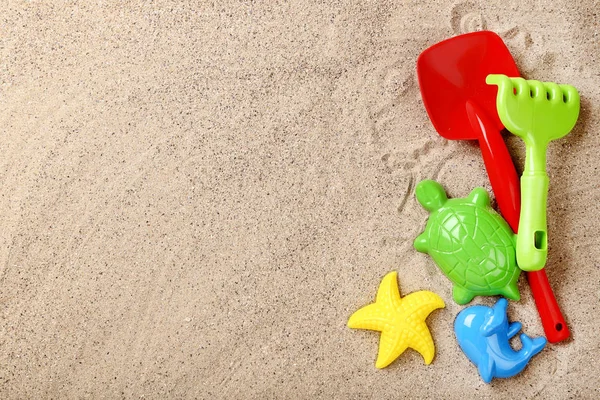 Brinquedos de plástico coloridos na areia da praia — Fotografia de Stock