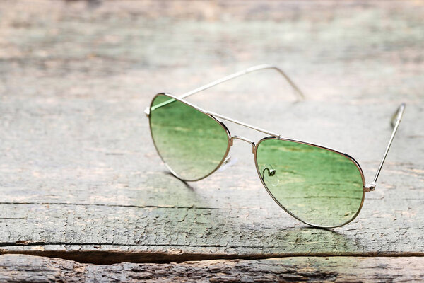 Fashion sunglasses on grey wooden table