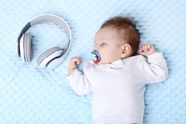 Мила дитина спить у ліжку біля навушників — стокове фото