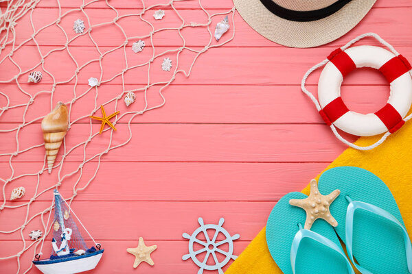 Fashion clothing with seashells and decorative ship on wooden ta