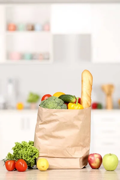 Grocery shopping bag with food on wooden table