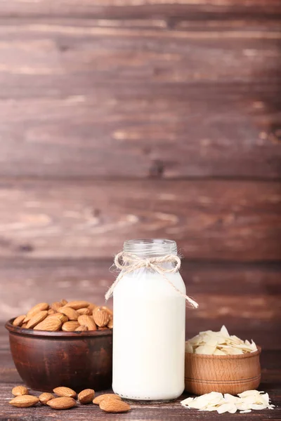 Amande et lait en bouteille sur table en bois marron — Photo