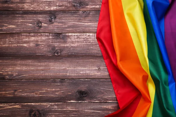 Bandera arco iris sobre mesa de madera marrón — Foto de Stock