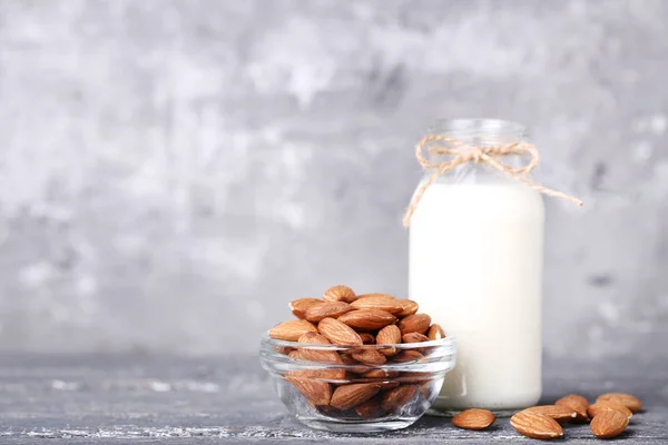 Lait d'amande en bouteille sur table en bois gris — Photo