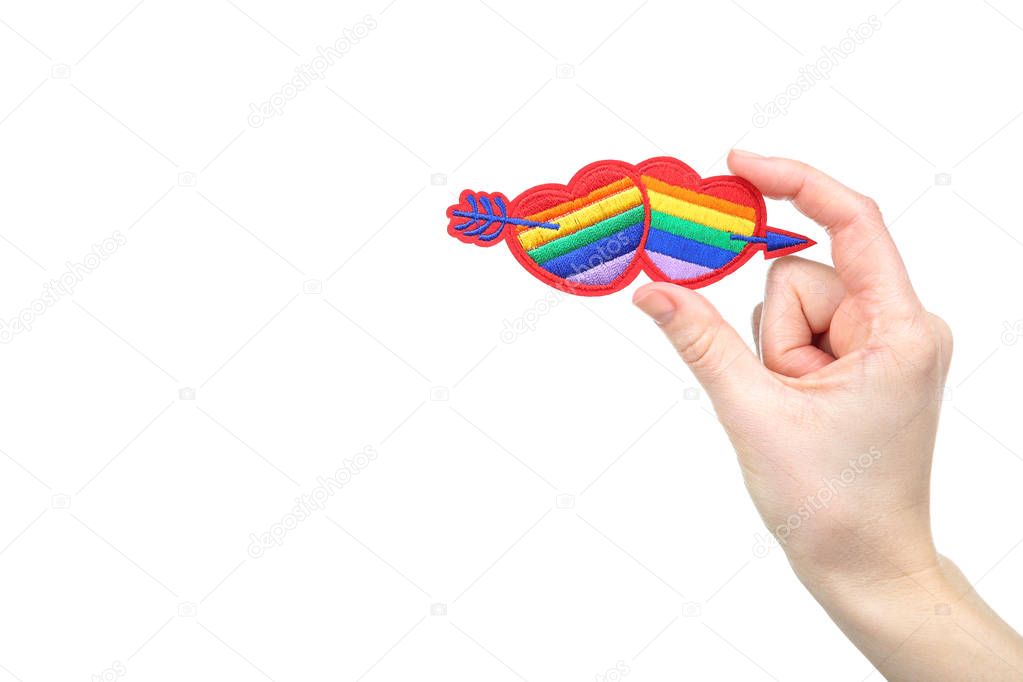 Female hands holding rainbow hearts with arrow on white backgrou