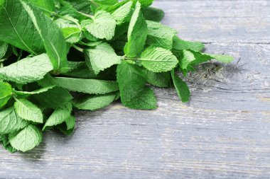 Gri ahşap masada nane yaprakları