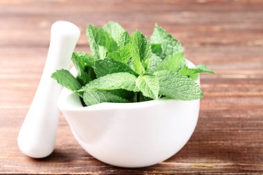 Kahverengi ahşap masada harç ile nane yaprakları