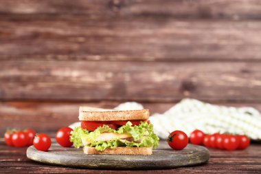 Kahverengi ahşap masa üzerinde taze sebze ile lezzetli sandviç