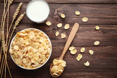 Mısır gevreği ahşap üzerinde buğday kulakları ve süt bardak ile kase 