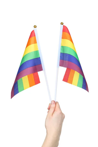 Vrouwelijke hand houden Rainbow vlaggen op witte achtergrond — Stockfoto