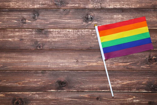 Rainbow flag on brown wooden table — Stock Photo, Image