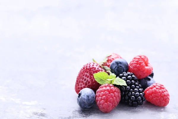 Reife und süße Früchte auf grauem Holztisch — Stockfoto