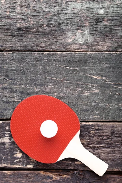 Raqueta de tenis de mesa con pelota sobre mesa de madera gris — Foto de Stock