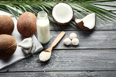 Ahşap masada pul ve şekerler ile şişehindistan cevizi sütü