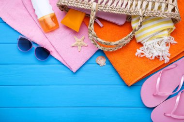 Mavi ahşap sekme üzerinde deniz kabukları ve güneş kremi ile Moda giyim