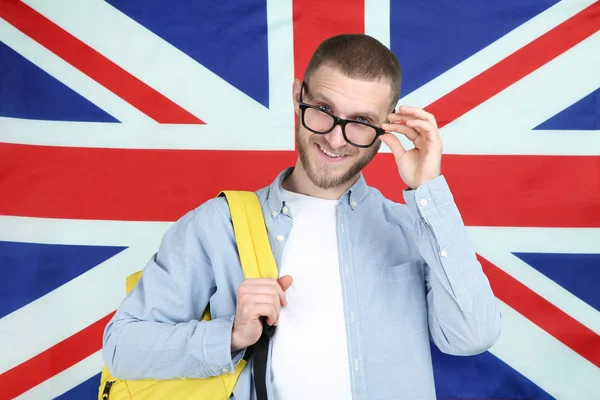 Young man with backpack on British flag background