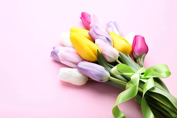 Ramo de flores de tulipán con cinta sobre fondo rosa —  Fotos de Stock