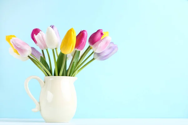 Ramo de flores de tulipán en jarra sobre fondo azul —  Fotos de Stock
