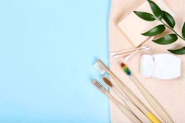 Mavi arka plan üzerinde sabun, pamuk çubukları ve diş ipi ile Bambu diş fırçaları