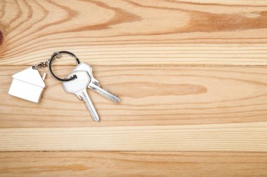 Kahverengi ahşap masa üzerinde ev sembolü ile gümüş tuşları