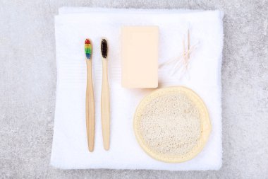 Gri arka plan üzerinde sabun, sünger ve pamuk çubukları ile Bambu diş fırçaları