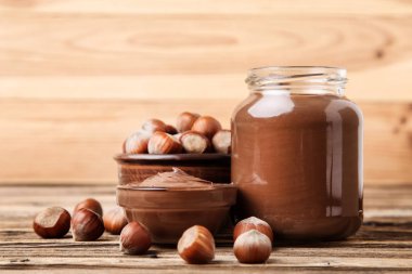 Kahverengi ahşap masada fındık ile erimiş çikolata