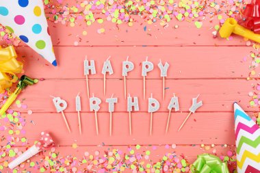 Ahşap masa üzerinde parti süslemeleri ile Happy Birthday mumlar