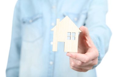 Ahşap ev modelini tutan kadın.