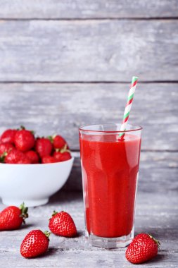 Gri ahşap masa üzerinde çilek ile cam Smoothie
