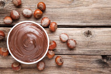 Kahverengi ahşap masada fındık ile erimiş çikolata