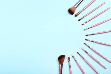 Mavi arka planda makyaj fırçaları seti