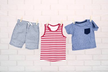 Tuğla duvar arka plan asılı bebek giysileri