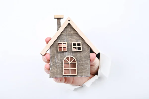 Hand holding houten huis model van wit gescheurde papier — Stockfoto
