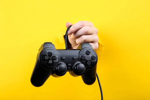 Kézi tartó joystick sárga tépett papírból — Stock Fotó