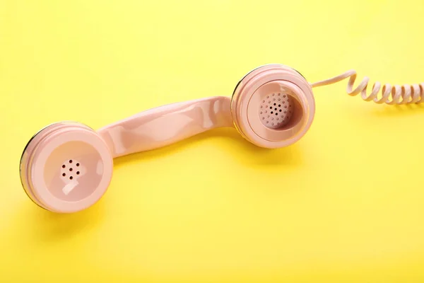 Fone de telefone rosa no fundo amarelo — Fotografia de Stock