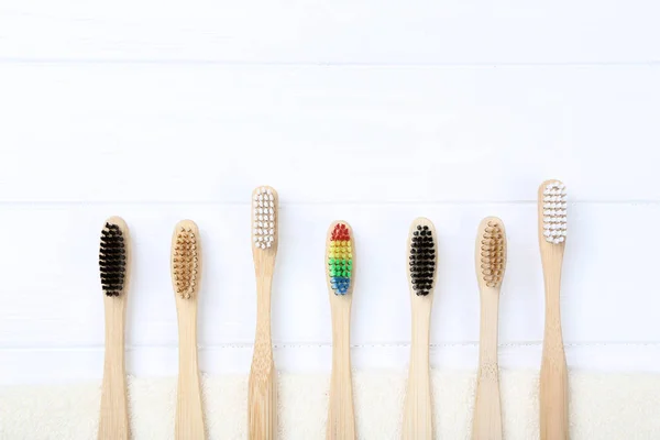 Bamboo toothbrushes on white wooden table — Stock Photo, Image