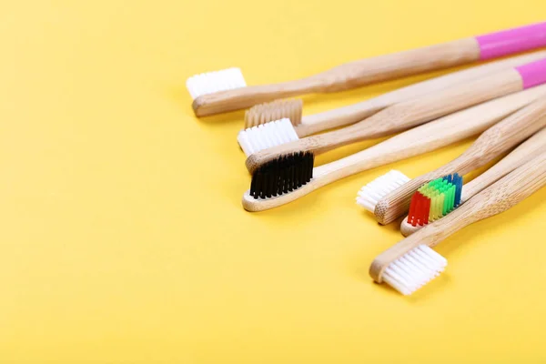 Bamboo toothbrushes on yellow background — Stock Photo, Image