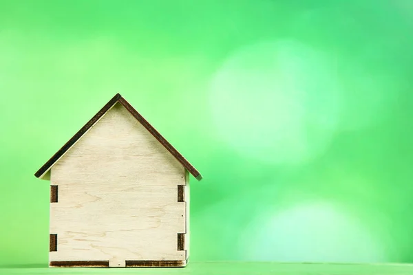 Деревянная модель дома на зеленом фоне — стоковое фото