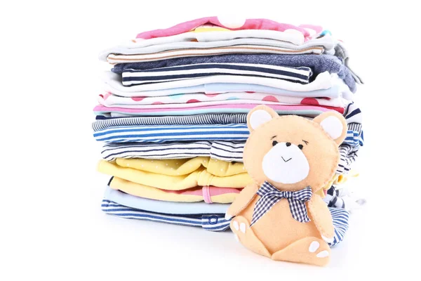 Roupas de bebê dobradas com brinquedo de urso macio isolado no backgro branco — Fotografia de Stock