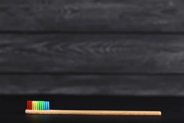 Bambu tandborste på svart träbord — Stockfoto