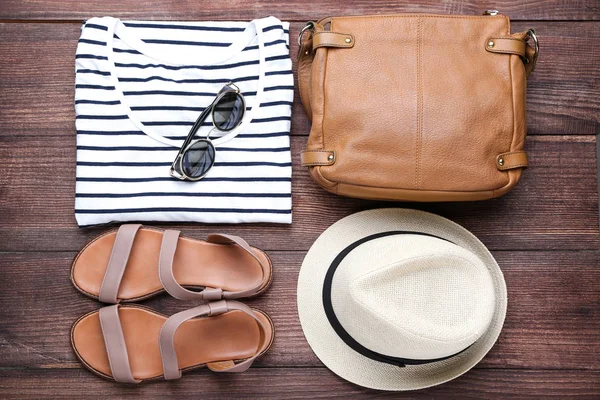 Ropa de mujer moderna con gafas de sol sobre mesa de madera marrón — Foto de Stock