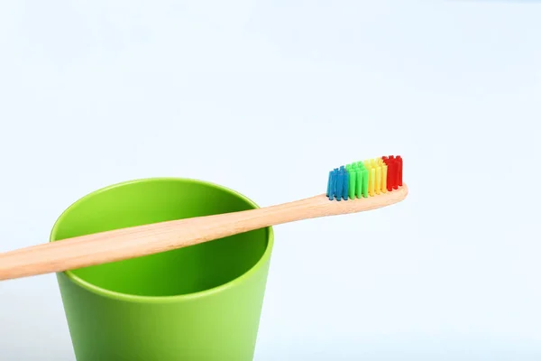 Bamboo toothbrush with green basket — Stock Photo, Image
