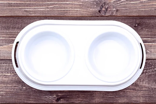 Empty pets bowls on brown wooden table