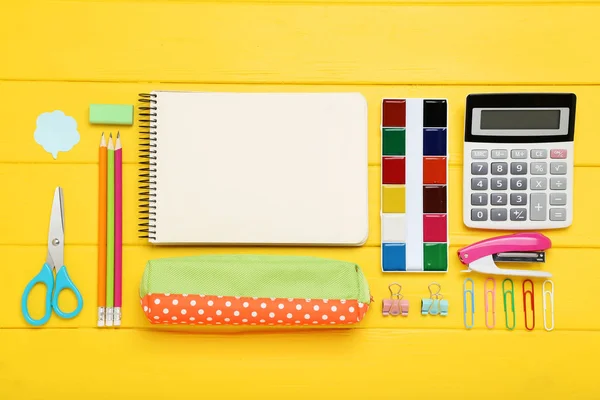 Schulbedarf mit leerem Blatt Papier auf gelbem Holztisch — Stockfoto