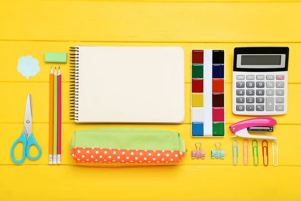 Fournitures scolaires avec feuille de papier vierge sur table en bois jaune — Photo